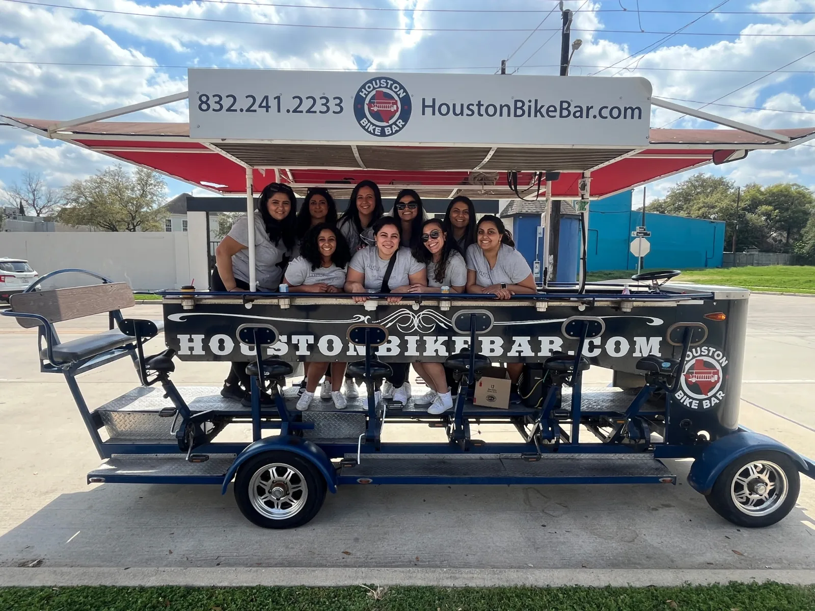 Sixteen riders aboard the Houston Bike Bar, cups in hand, on a sunny Houston afternoon