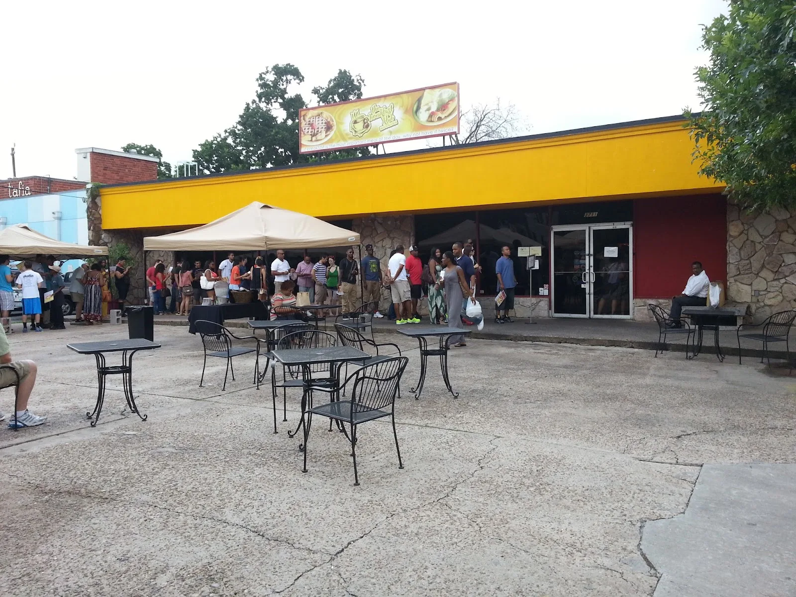 The yellow storefront and patio of The Breakfast Klub in Midtown Houston