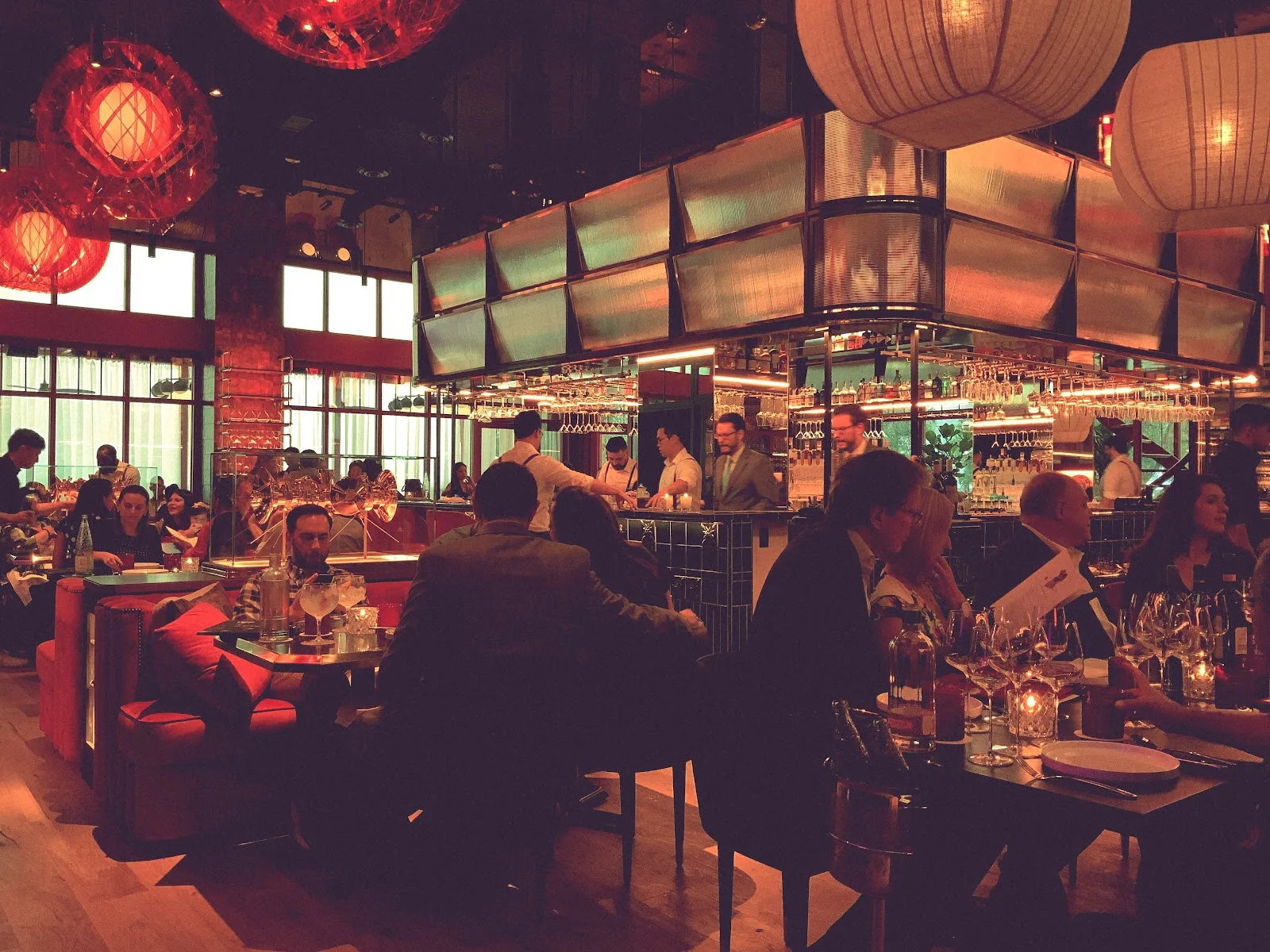 The red-lit dining room and bar at MAD in Houston&rsquo;s River Oaks District