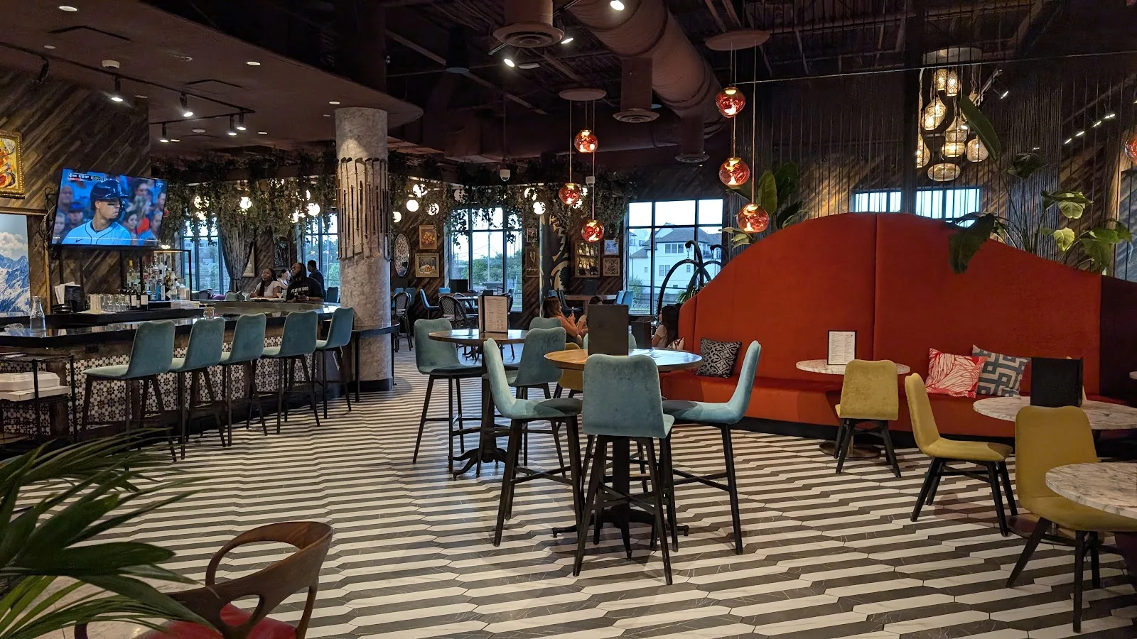 The bar and lounge at Puttery on Washington Avenue, with striped floors, velvet stools and a curved red banquette