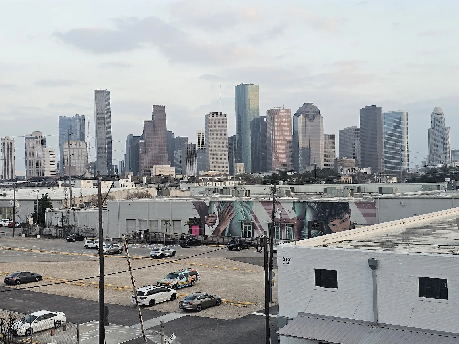 The downtown Houston skyline seen over the mural-covered warehouse studios of Sawyer Yards