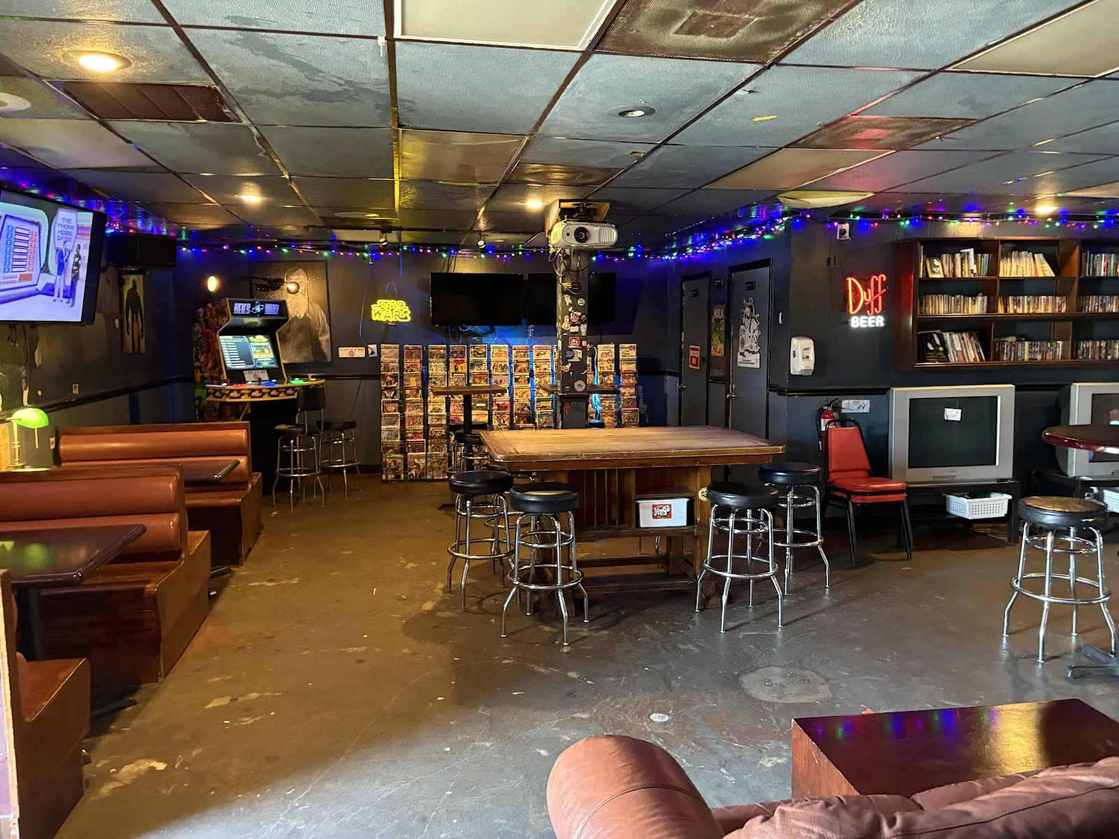Booths, an arcade cabinet and racks of comic books inside Neil&rsquo;s Bahr at its new McKinney Street location