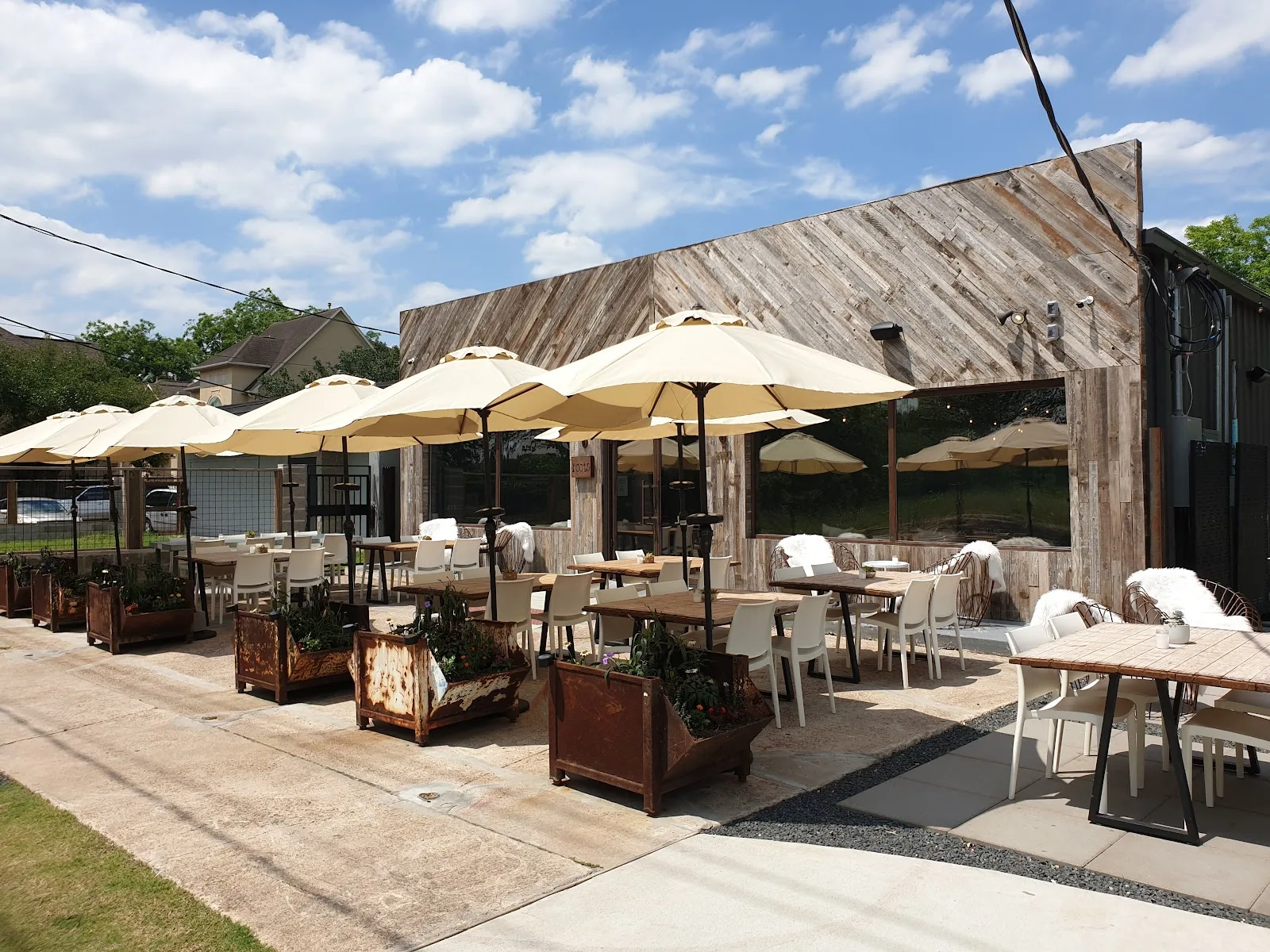 The umbrella-shaded front patio at Roots wine bar on Leeland Street