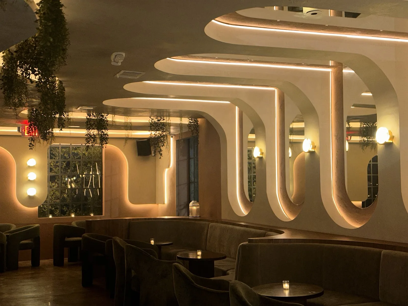 Curved velvet banquettes under backlit arches inside Melrose on Ralph Street