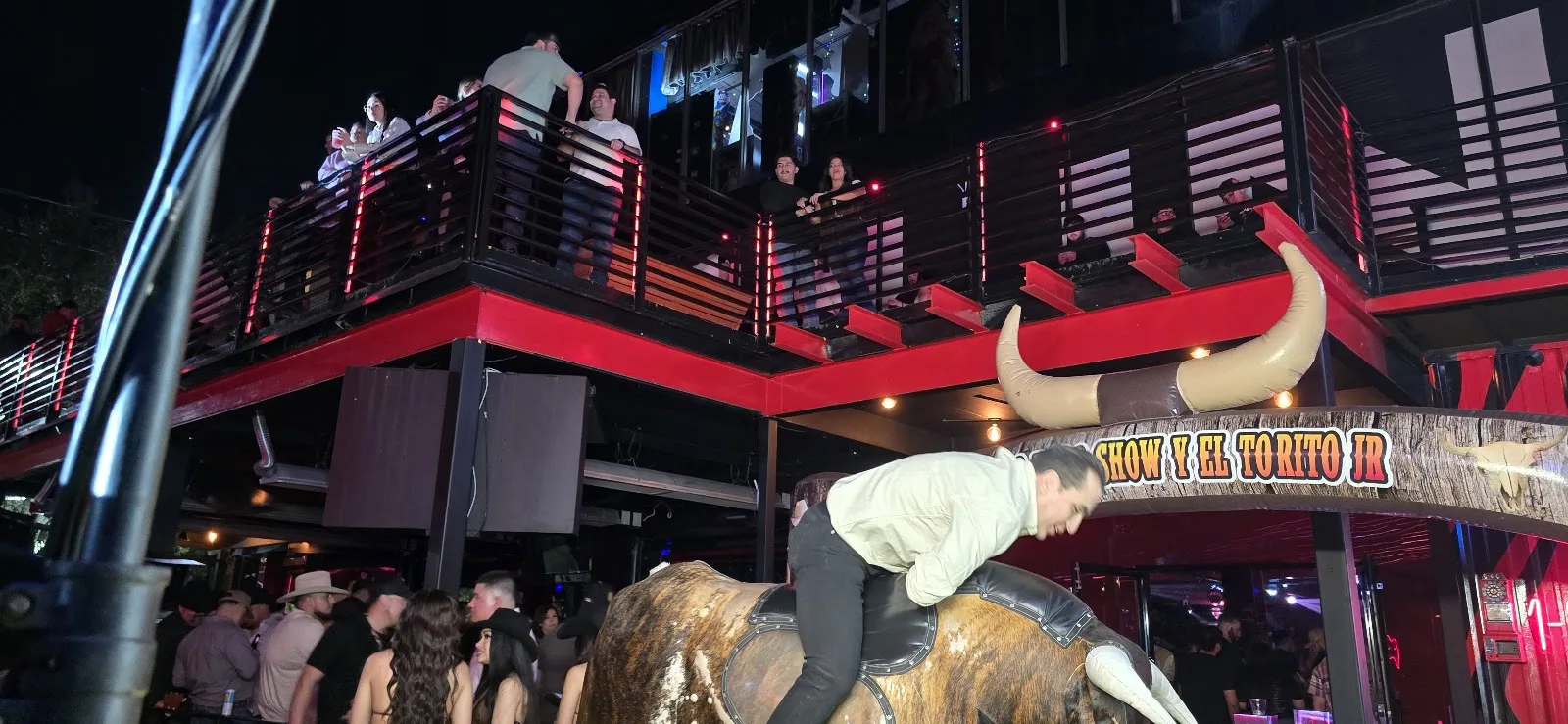 A crowd around the mechanical bull below the balcony at Medellin in Midtown Houston