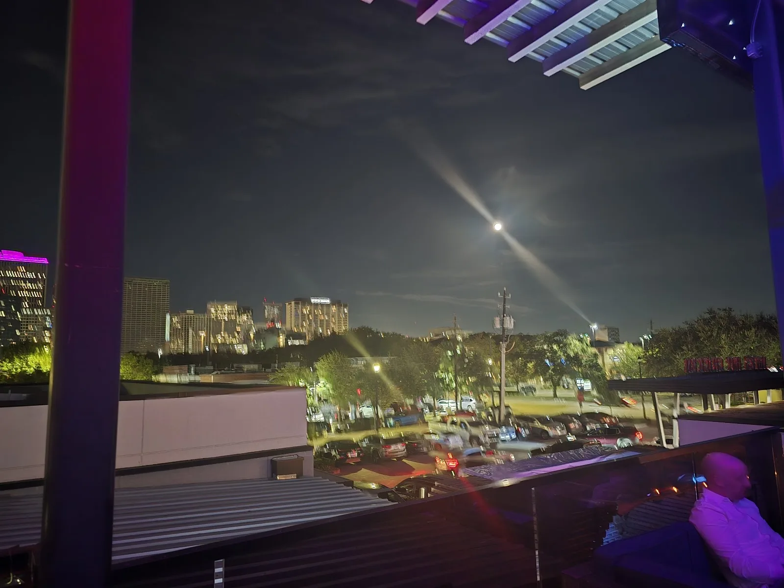 The Houston skyline and a full moon seen from the rooftop at Reset in Midtown at night