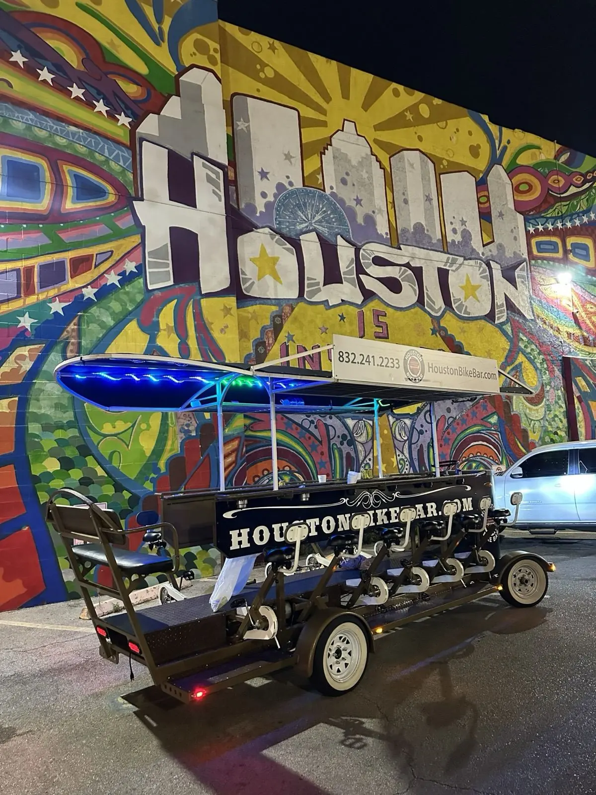 The bike bar riding at night past string lights