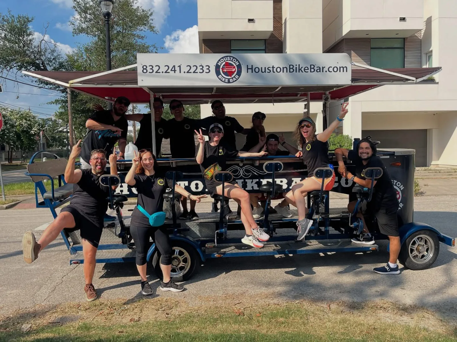 A big group posing with the Houston Bike Bar outside Minute Maid Park